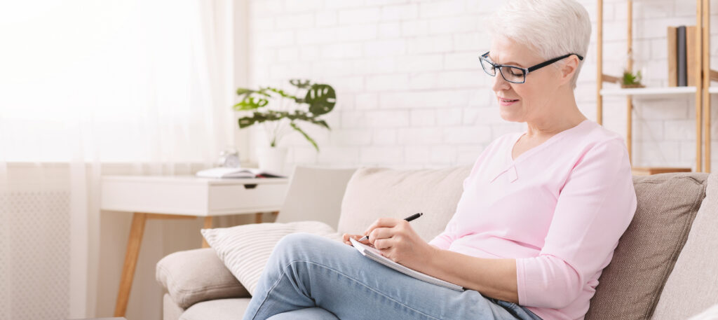 An older woman writing a letter