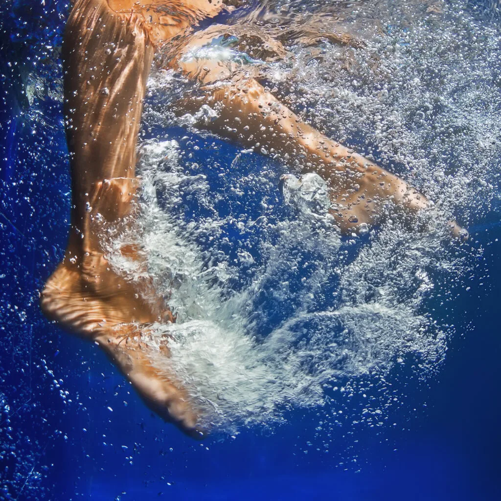 a woman's feet kicking in water