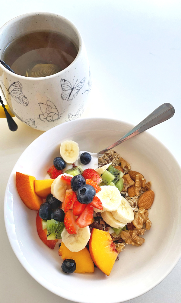a cup of tea and granola with fruit - a clean breakfast