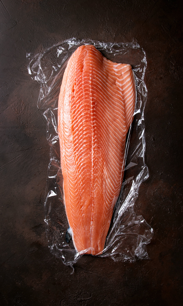 salmon wrapped in plastic wrap ready to be prepared for cooking
