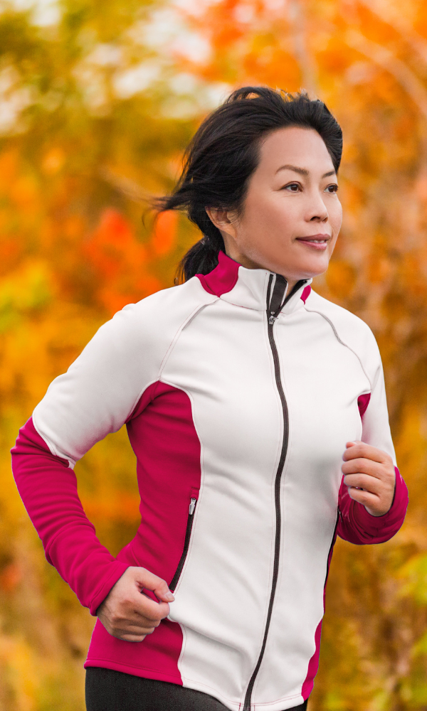 a woman running in a park on a fall day